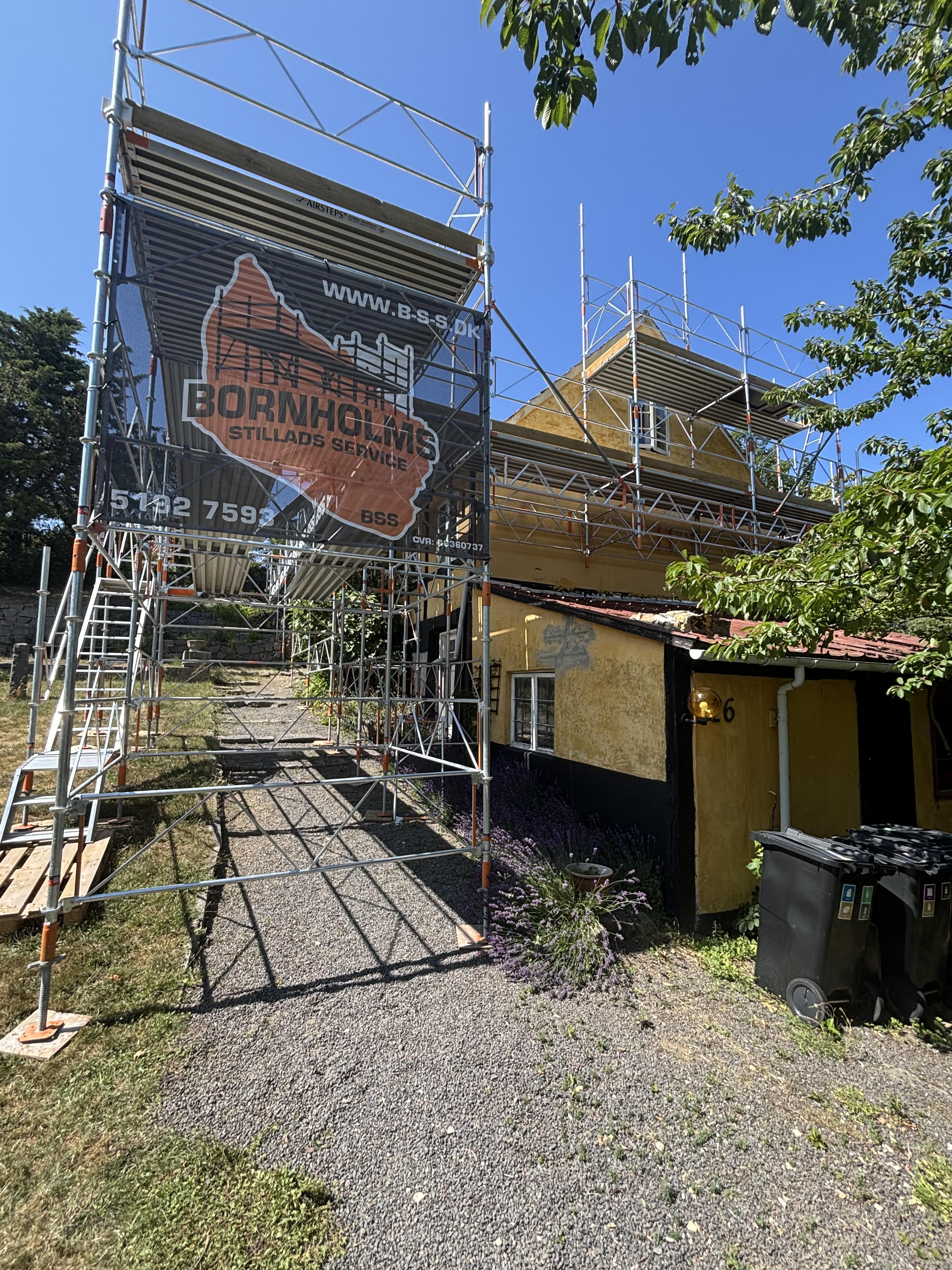 Stillads med BSS-banner opsat om hus på Bornholm — Bornholms Stillads Service